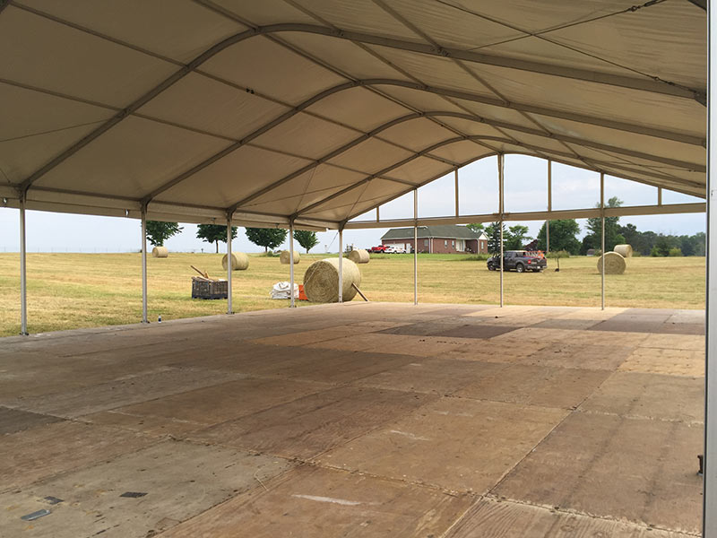 Tent manufacturers setting up venue for outdoor event.